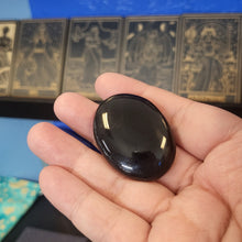 Load image into Gallery viewer, Hand holding a black object against a blurred background with intricate designs