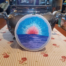 Load image into Gallery viewer, Hand embroidered landscape with a sunrise with blue skies above a body of water
