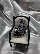 Load image into Gallery viewer, image is a clear high-heeled boot with white lacing and a pink heart. background has black and pink swirls
