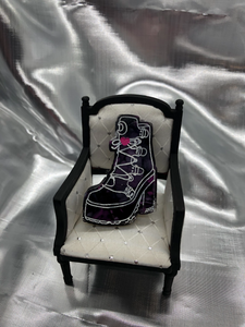 image is a clear high-heeled boot with white lacing and a pink heart. background has black and pink swirls