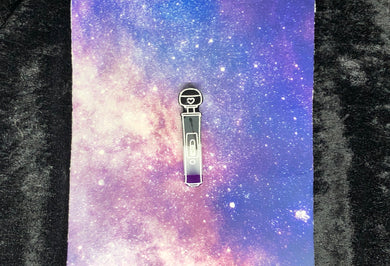 A hitachi magic wand earring with ace pride colors (black, grey, white, and purple) and bright white highlights on a pink-and-blue nebula and black crushed velvet background.