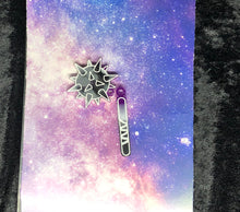 Load image into Gallery viewer, spiked flail earring with ace pride colors (black, grey, white, purple) and bright white outlines against a pink-and-blue nebula and black crushed velvet background
