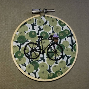 Hand embroidered hoop art of a bicycle with basket of flowers