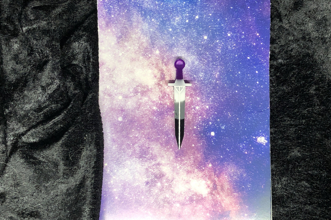 ace pride flag (black, gray, white, purple) long sword earring with bright white outlines against a pink-and-blue nebula and black crushed velvet background