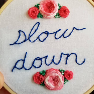 Hand embroidered modern art hoop with roses and a reminder to relax and slow down to help reduce anxiety and stress